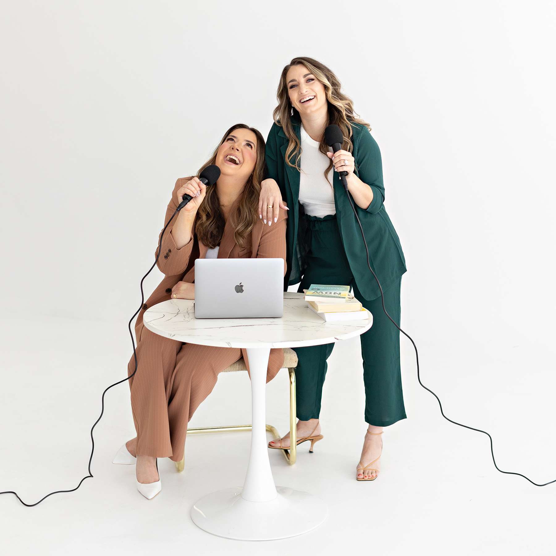 two female entrepeneurs recording their podcast and laughing