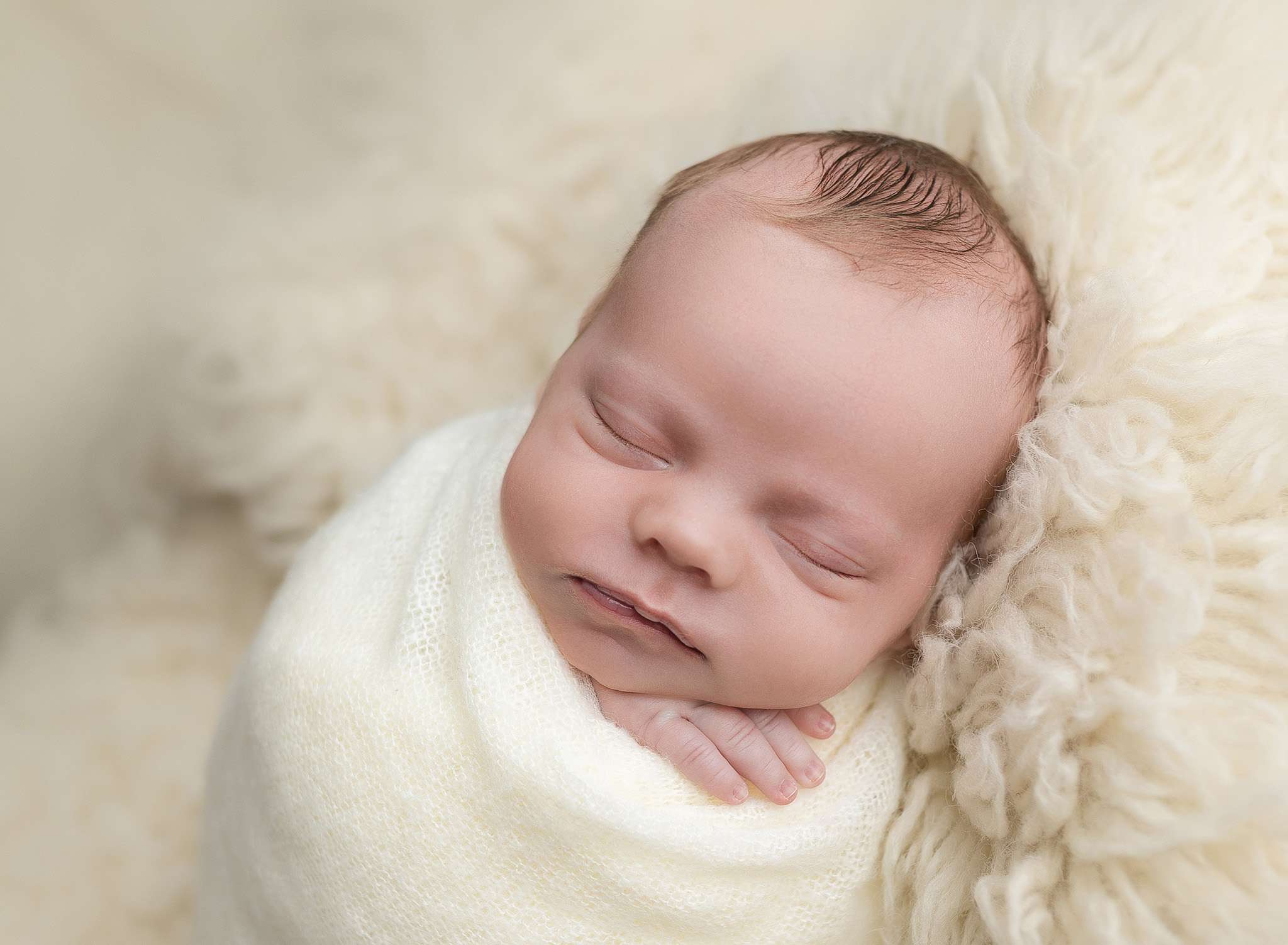 Newborn baby wrapped in a soft blanket capture in La Jolla's newborn photography studio