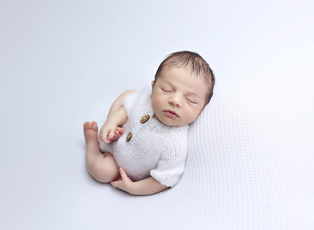 Newborn baby sleeping peacefully in a posed setup, captured by a talented San Diego newborn photographer, preserving precious memories.